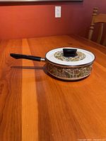 saucepan with lid side view showing handle and pattern