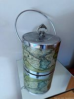 Full view of ice bucket showing lid, handle and map design