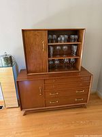 Front view of two-piece wood hutch showing upper display section and lower drawer cabinet