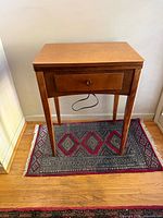 Front view of closed sewing machine cabinet on rug