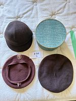 Group shot of three hats and hat box