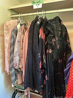 Rack of seven vintage women’s garments showing colors, fabrics and patterns