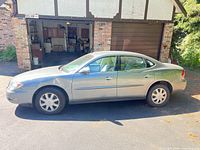 Left side view of grey 2005 Buick LaCrosse CX parked in driveway