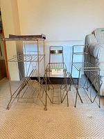 Overall view of three brass wire stands and brown plastic LP holder
