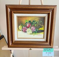 Framed oil painting on easel showing full view and dimensions tag