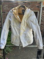 Front view of jacket showing pockets, hood, zipper