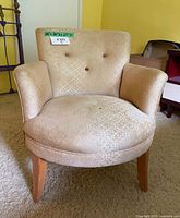 Front view of beige patterned tufted accent chair showing overall design and condition