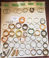 Full layout of all bangles and bracelets including labelled bags for Monet, West Germany, Stainless, Genuine Copper and 925 Silver