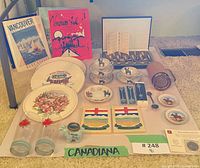 overview of entire lot showing books, plates, spoons, glassware and plaques