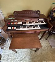 Front view of Conn console organ with bench showing overall appearance and accessories