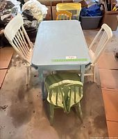 Top view of blue table with four painted chairs around it