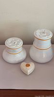Two covered jars and heart trinket box white porcelain with gold trim
