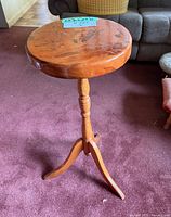 Full view of round pine pedestal table showing top, column and base