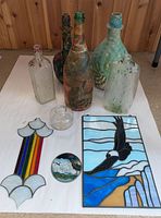 Group shot of stained glass pieces and glass bottles on white background
