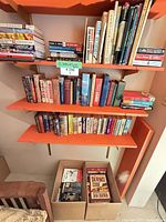 Wall shelves and boxes filled with assorted hardcover, trade and mass-market paperbacks