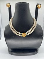 Necklace displayed on bust with matching earrings visible