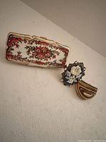 Front view of all three brooches showing designs and materials