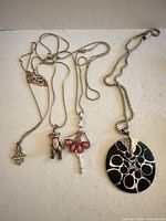 All four necklaces laid out showing pendants and chains
