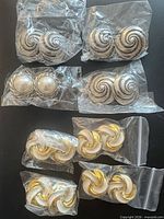 All eight pairs in plastic sleeves showing three designs