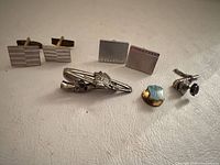 overall view of both cufflink pairs, tie clip, and lapel pins