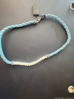 Full view of turquoise braided leather pearl choker necklace with clasp and tag visible