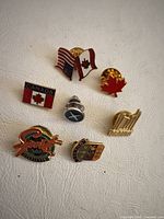 Front view of seven pins displaying designs