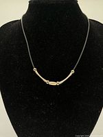 Necklace displayed on black bust showing front detail