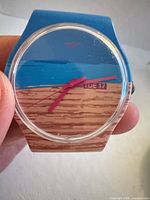 Front view showing dial, hands, day-date window, pine wood pattern