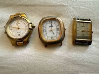 Three gold-tone quartz watches laid out side by side