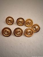 Seven gold-tone Trifari round earrings front view
