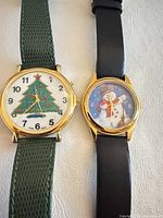Both holiday watches side by side showing cases, dials, and straps