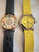 Front view of both wristwatches displaying dial designs and straps