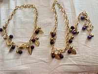 Overview of two necklaces and bracelet with leaf and berry charms