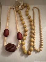 Three necklaces laid flat showing overall design and shapes
