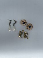All three earring pairs laid out: faux pearl drops, rope blue stone, rhinestone floral leaf
