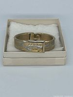 Closed bangle watch resting in presentation box, cover visible