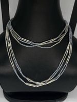 Full view of necklace displayed on bust showing multi-strand layout and bead types