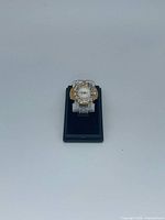Ring watch on display stand, full view