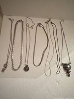 All six silver-tone necklaces laid out
