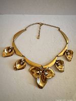 Full view of necklace with five floral drops and collar segments