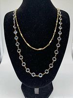 Both necklaces displayed on black bust; Swarovski in front and Napier shorter behind