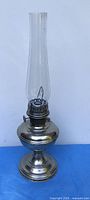 Full view of nickel-plated brass oil lamp with tall glass chimney