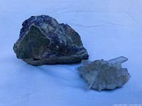 Amethyst matrix rock beside clear quartz cluster