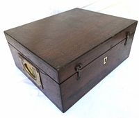 Three-quarter view of closed wooden case showing overall form and patina