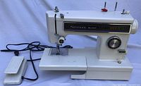 Full view of sewing machine with foot pedal and cord