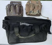 Front view of two leather pouches and Craftsman tool bag