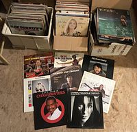 Overview of three boxes of LPs showing spines and several records laid out