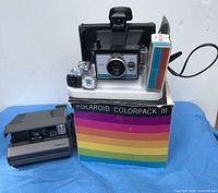 Overall lot showing both cameras, box, flashcubes and cable