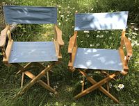 Two wooden director's chairs on grass showing overall design and condition