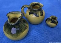 three pitchers showing size comparison and glaze colors